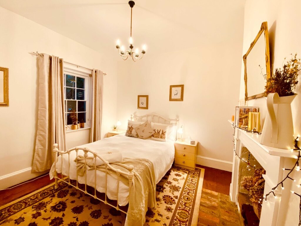 Bonneys cosy bedsit room with double bed, side tables and decorative fireplace